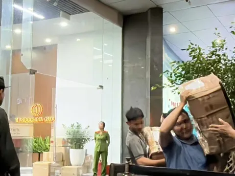 Cảnh sát vận chuyển nhiều thùng niêm phong ra khỏi tòa nhà có trụ sở công ty Shark Bình